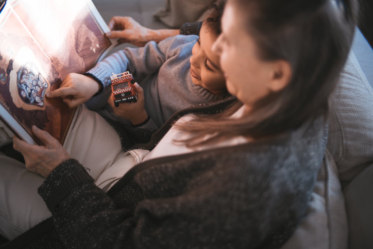 Grandmother and child enjoying a cozy afternoon reading together indoors.